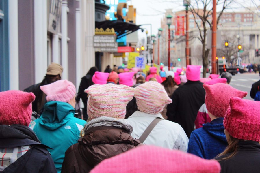 A+sea+of+knitted%2C+pink+pussy+caps+flood+out+of+the+metro+station+into+the+bright+streets+of+Washington+DC.