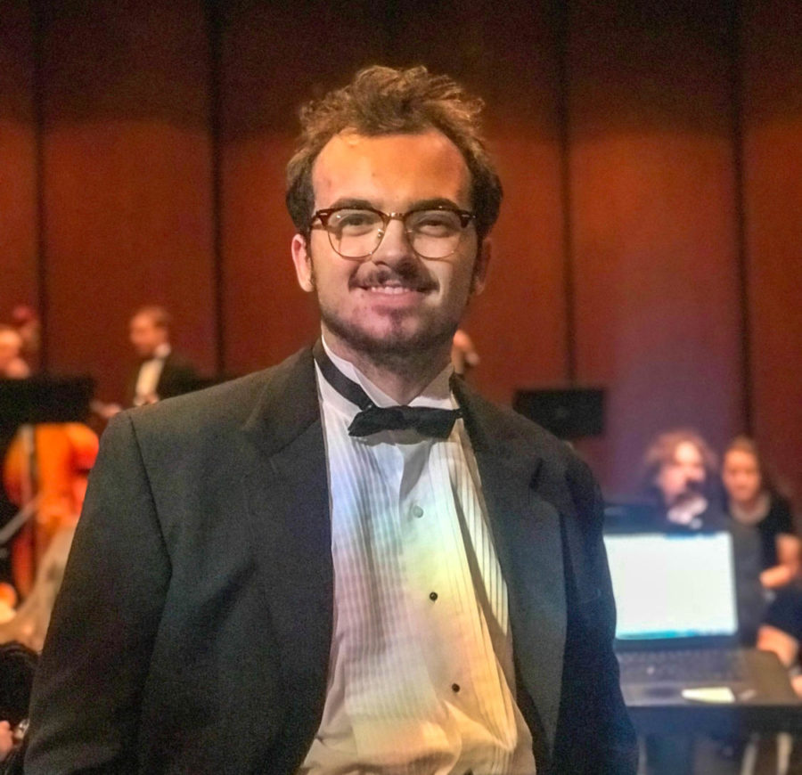 Orchestra director, Drew Johnston 19, poses for a picture following the Harmony for Humanity concert.