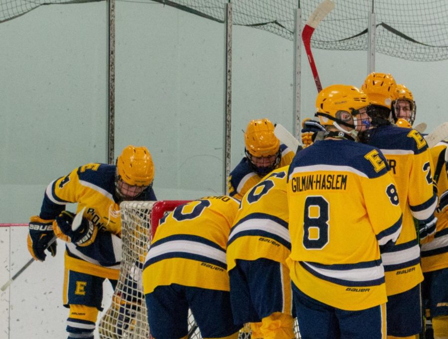 The boys hockey team gathers in a huddle at Patterson Ice Center during their first game of the season against Jenison high school.