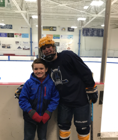 Nathan Milanowski 21 with Ayden at a East Hockey game.