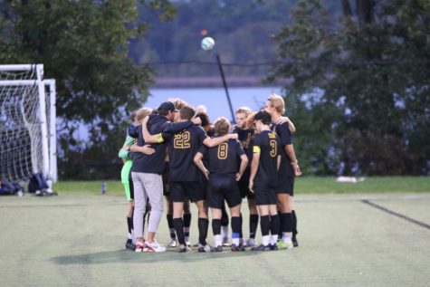 The soccer team huddles before the start of a game at Memorial Field