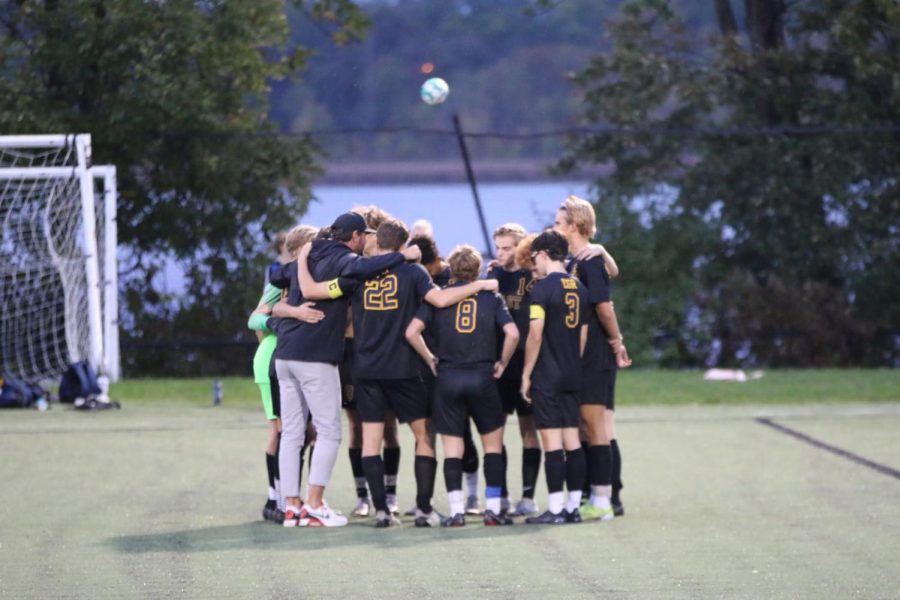 The+soccer+team+huddles+before+the+start+of+a+game+at+Memorial+Field