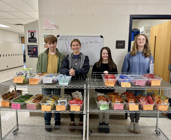 Snack entrepreneurs stand in front of the cart ready for business. (L-R) AJ Hafer, Kennidi Kowal, Lauren Hecksel, and Zoe Boogaart welcome customers.